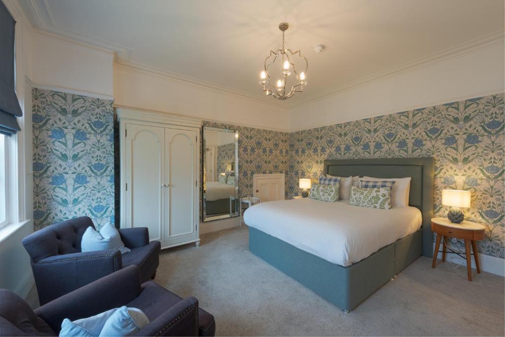 a bedroom with a bed and a chair and a couch at Florence House Boutique Hotel and Restaurant in Portsmouth