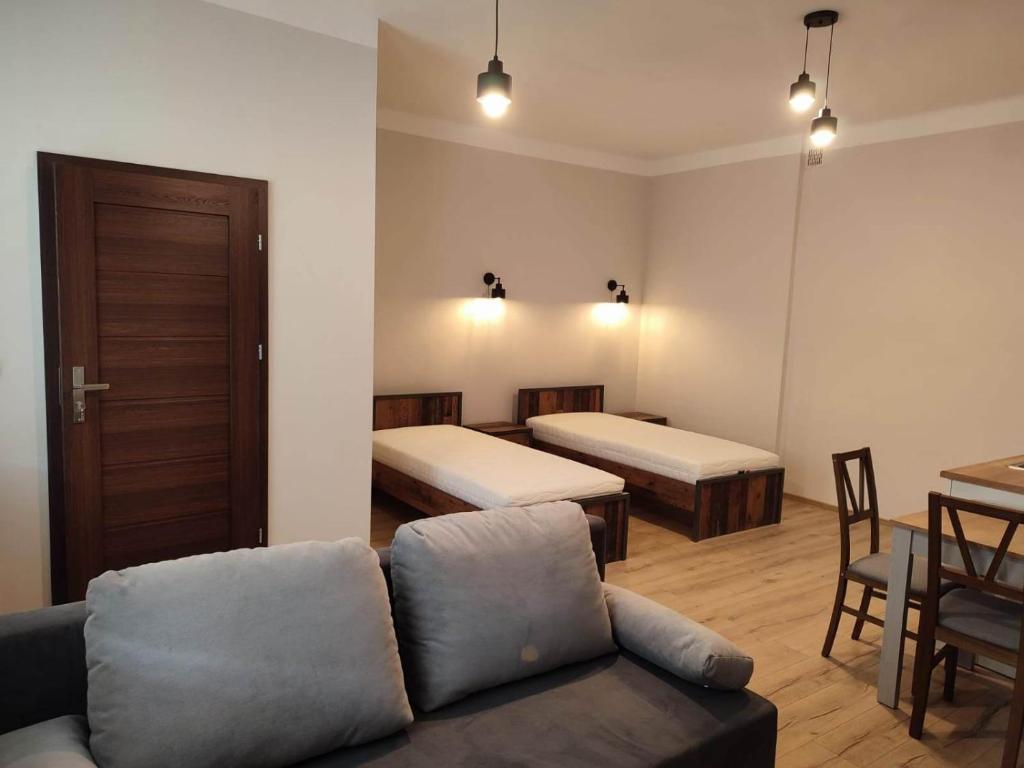 sala de estar con 2 camas y sofá en Apartamenty ,,Pod Klonem'', en Sandomierz