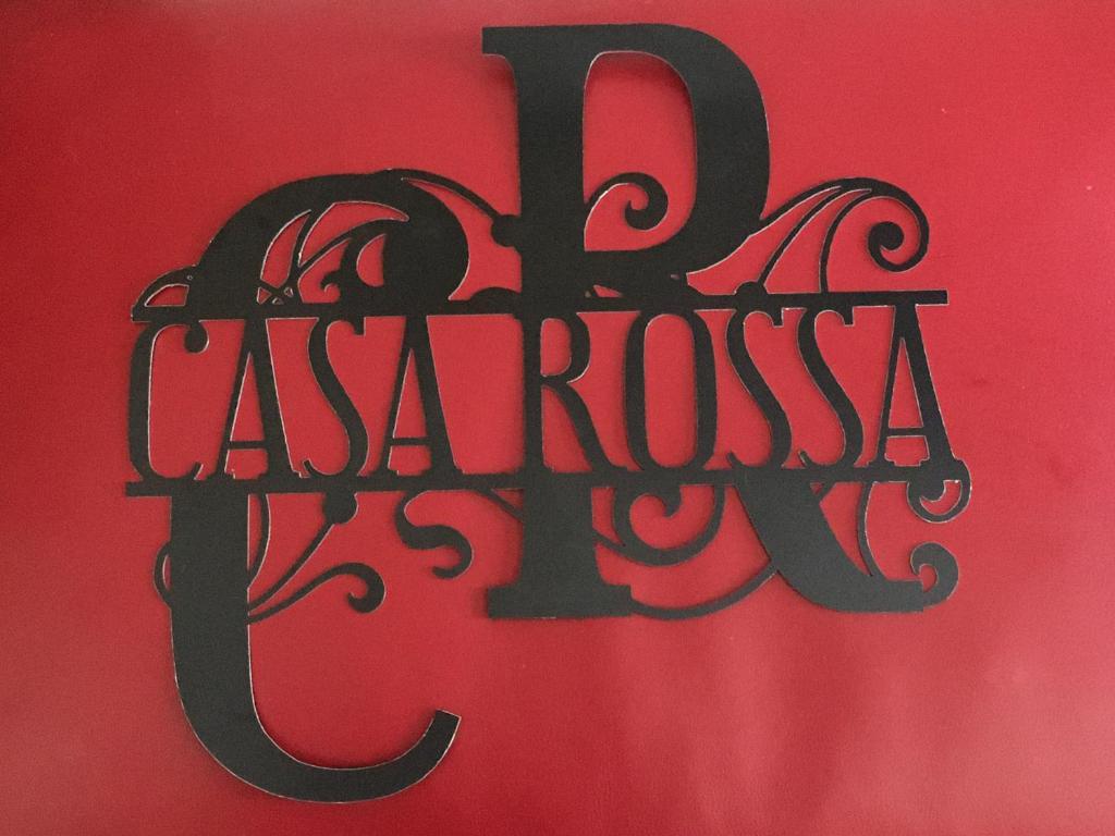 un panneau sur un mur rouge avec le mot "casket" dans l'établissement Casa Rossa, à Portovenere
