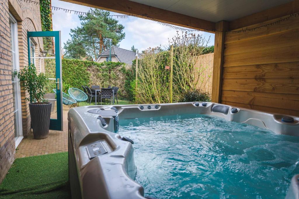 a hot tub in the backyard of a house at Luxe Veluws Vakantiehuis met JACUZZI in Lunteren