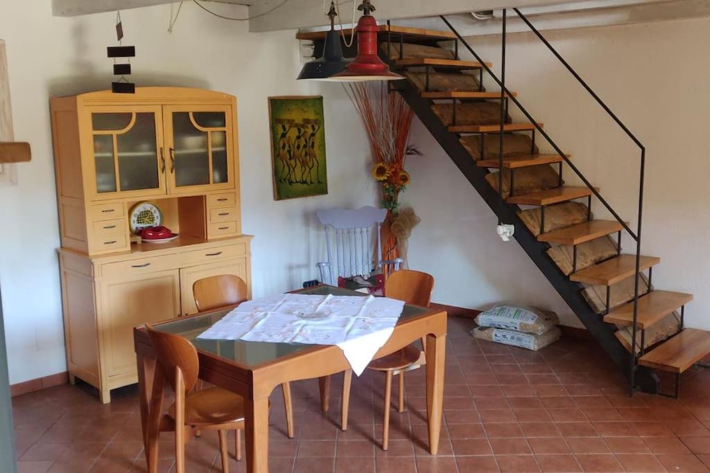 una sala da pranzo con tavolo e scala di Casa Camino a Rubiana