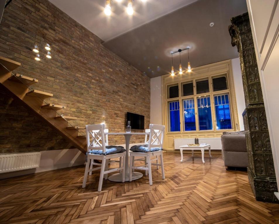 - un salon avec une table et des chaises ainsi qu'un mur en briques dans l'établissement VISAJ Deluxe Downtown, à Timişoara