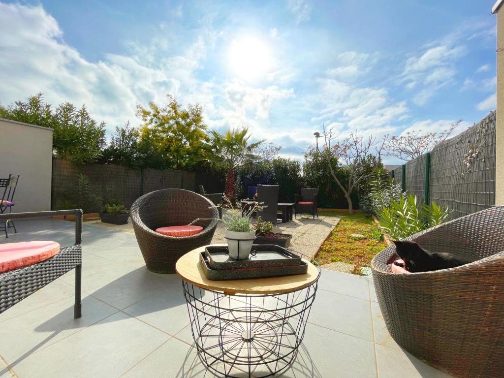 einen Garten mit einer Terrasse mit einem Tisch und Stühlen in der Unterkunft Villa Sète, 4 pièces, 6 personnes - FR-1-338-370 in Sète