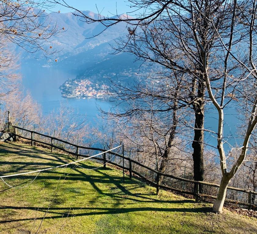 a hill with a fence and a view of a lake at Il Riccio appartamento in Cernobbio