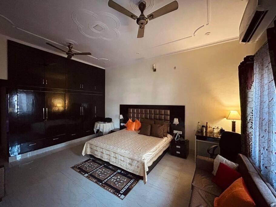 - une chambre avec un lit et un ventilateur de plafond dans l'établissement Bisht Niwas Homestay, à Kotdwāra