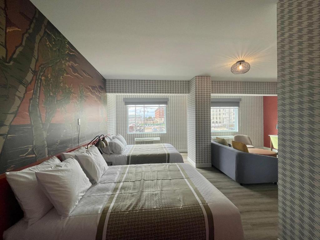 a bedroom with three beds and a large painting on the wall at Superior Shores Hotel BW Signature Collection in Thunder Bay