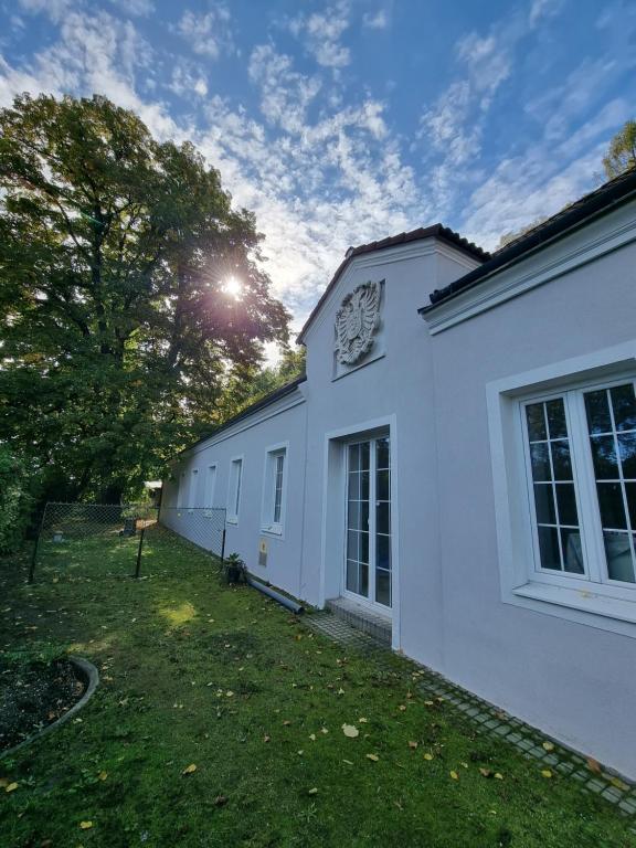 ein weißes Gebäude mit einem Hof neben einem Baum in der Unterkunft Altes Zollhaus in Höflein an der Donau