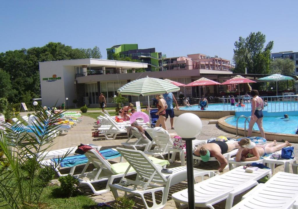 a group of people laying on lounge chairs by a pool at Kims One-bed Apart for rent at Sunny Beach Resort in Sunny Beach