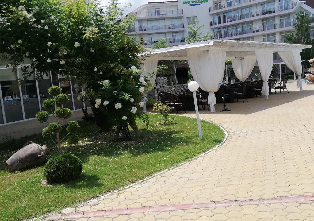 a pavilion with white curtains and a table and chairs at Kims One-bed Apart for rent at Sunny Beach Resort in Sunny Beach