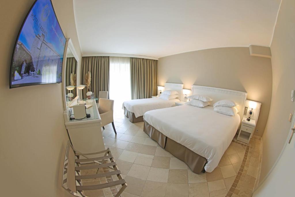 a hotel room with two beds and a staircase at Hôtel L'Abbaye in Calvi