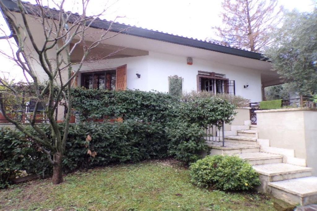 a white house with stairs in front of it at Villetta Mazzini Front Lake - Happy Rentals in Peschiera del Garda