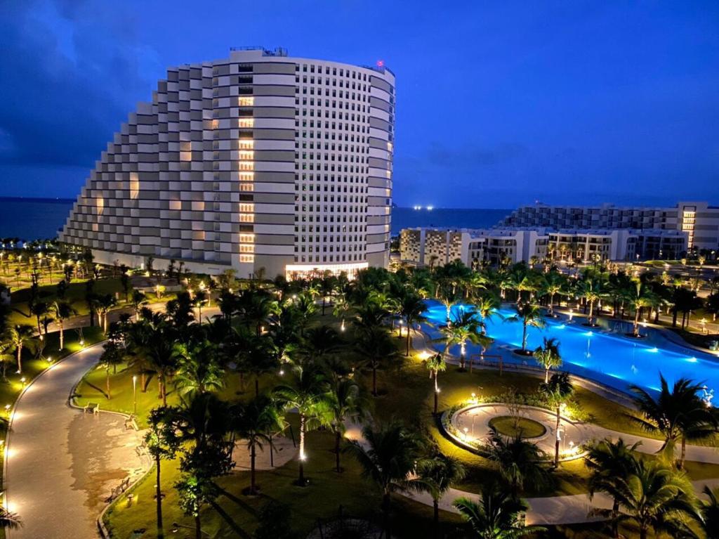 uitzicht op een gebouw met palmbomen bij Arena Cam Ranh Beach resort in Miếu Ông