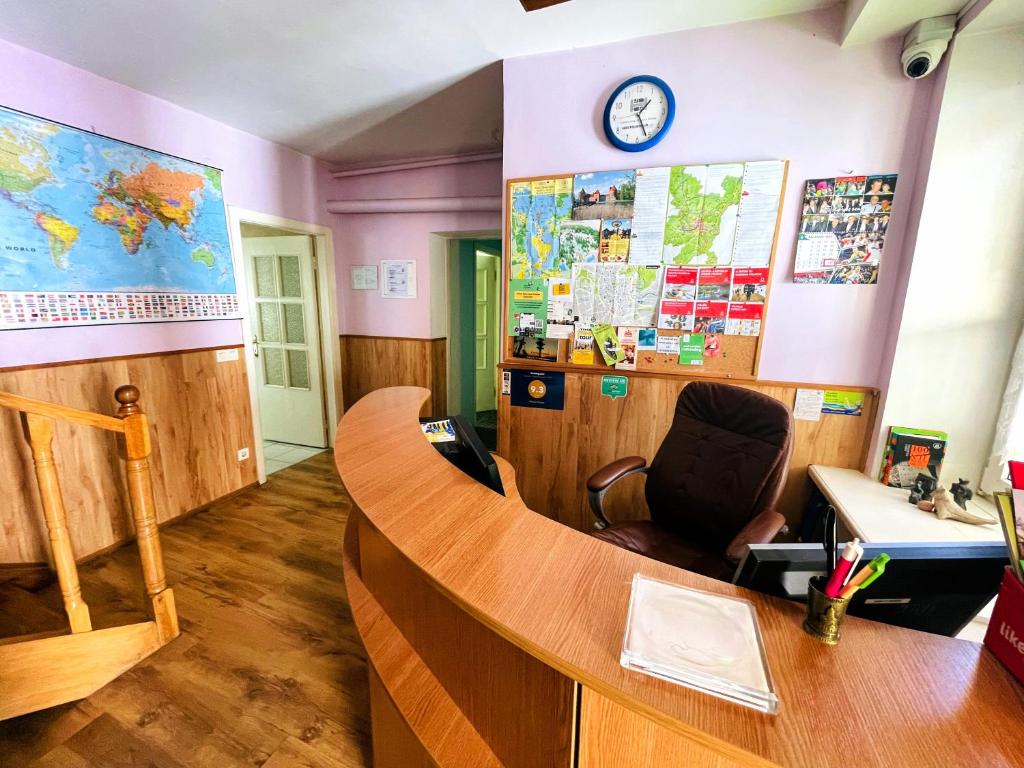 a classroom with a desk and a clock on a wall at Mikalo House in Vilnius