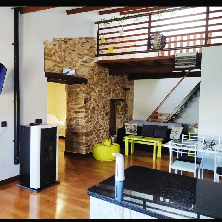 a living room with a table and a stone wall at Casa das Pozas in Distriz