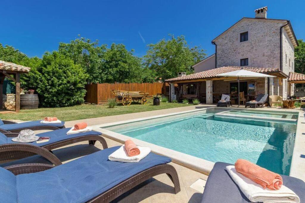 a villa with a swimming pool and a house at Villa Histria - Adriatic Luxury Villas in Manjadvorci