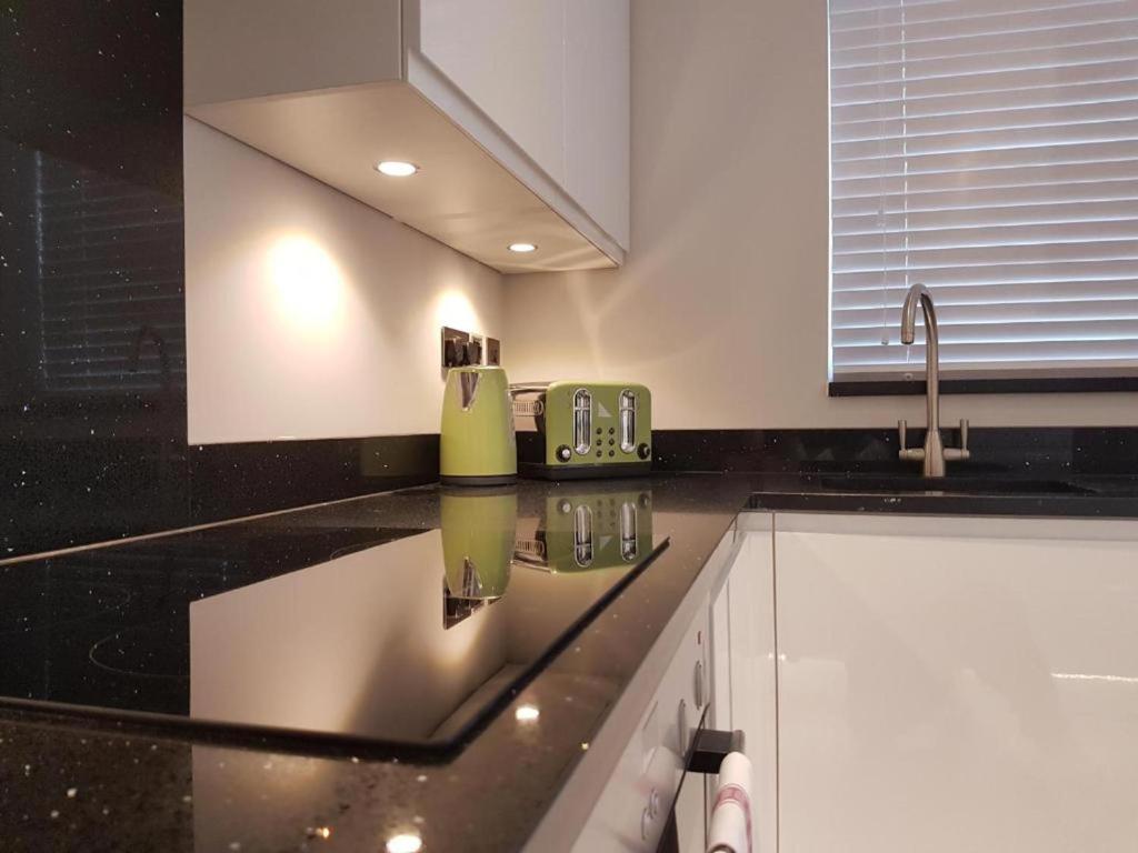 una cocina con encimera negra y fregadero en Captivating 2-Bed Apartment in Brentwood, en Brentwood