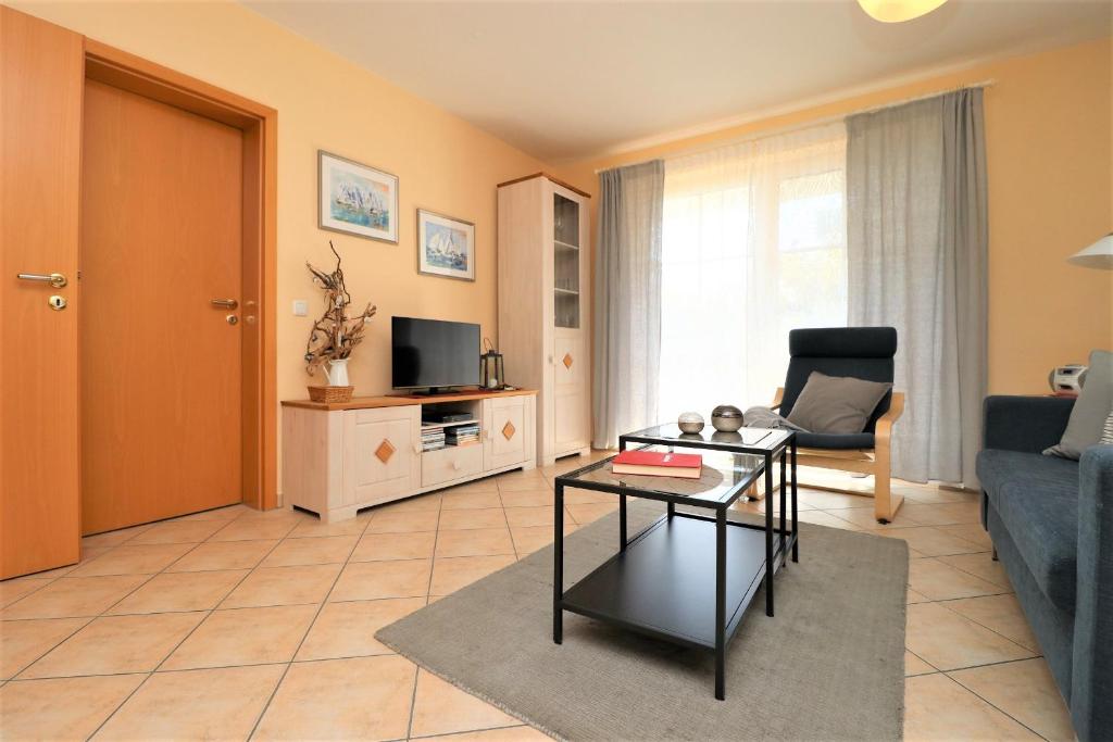 a living room with a blue couch and a table at Altes Wasserwerk App 02 in Wustrow