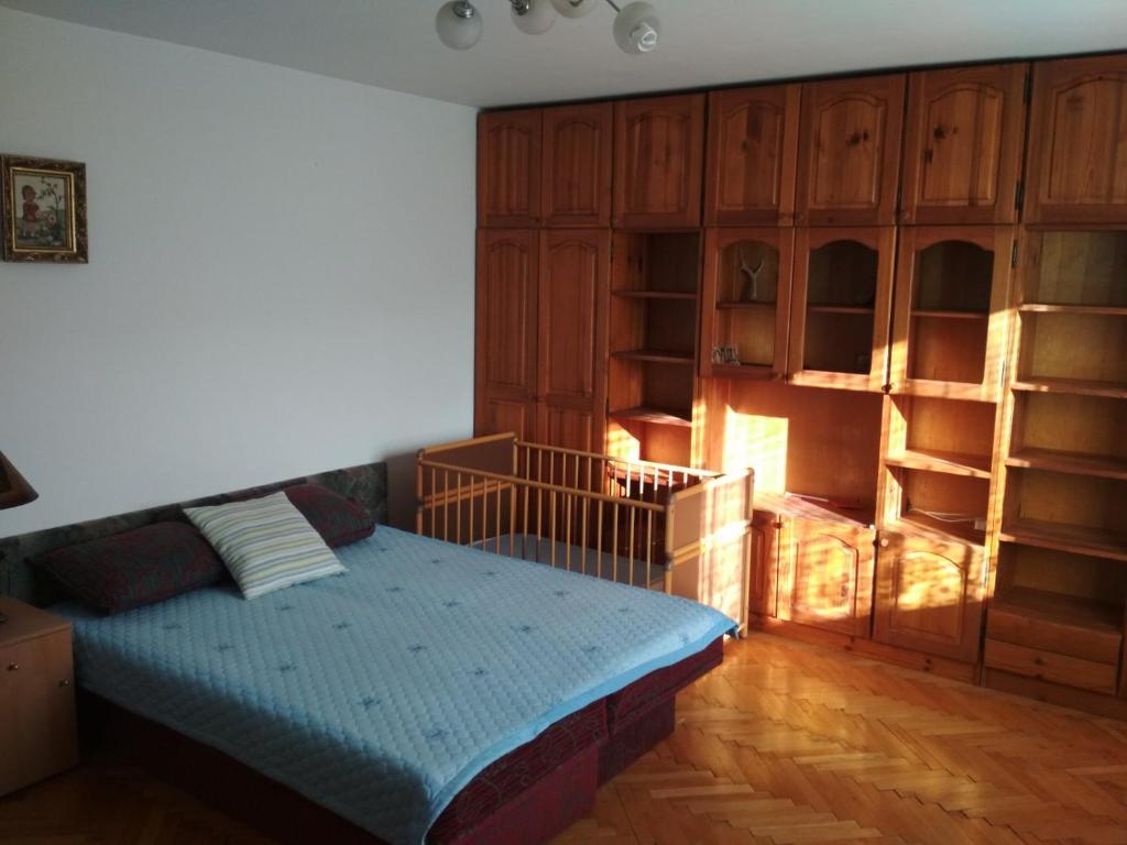 a bedroom with a bed and wooden cabinets at Dušanov Konak in Bajina Bašta
