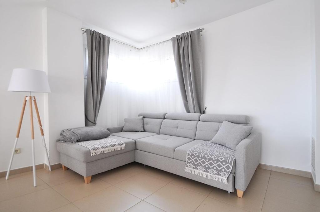 sala de estar con sofá y ventana en Santa Clotilde, en Lloret de Mar