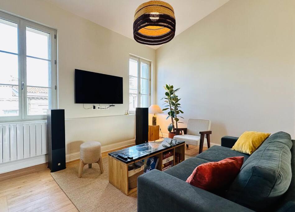 a living room with a couch and a flat screen tv at Panorama des Chartrons in Bordeaux