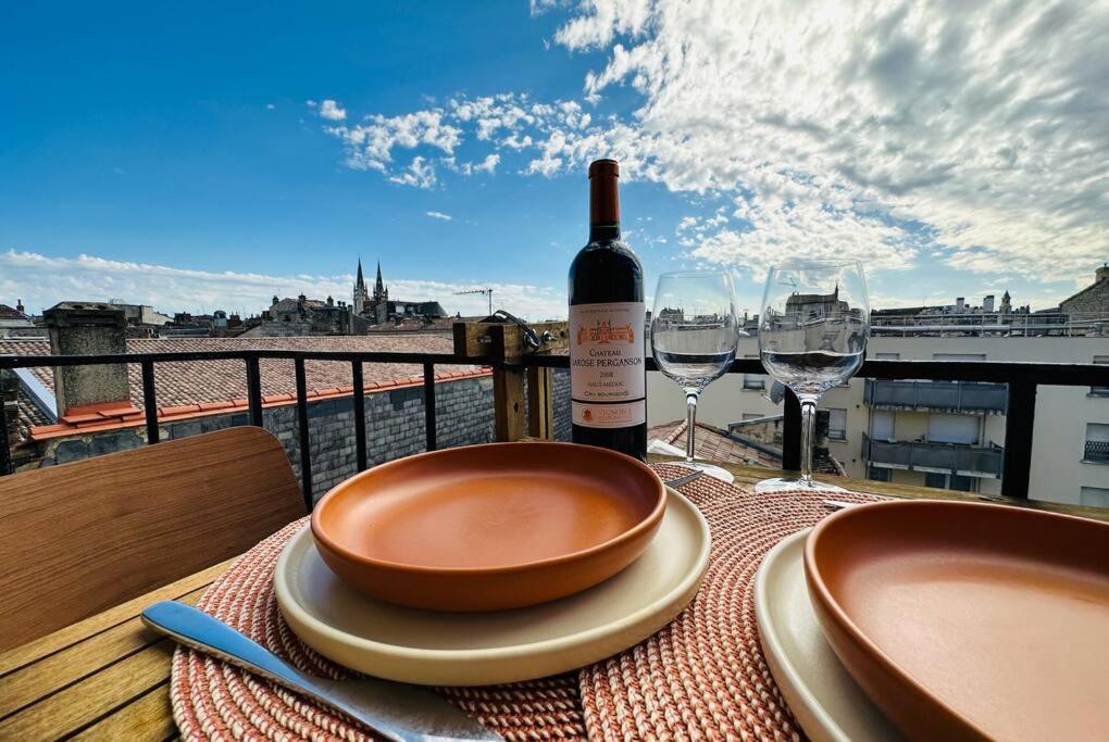 a bottle of wine and two glasses on a table at Panorama des Chartrons in Bordeaux
