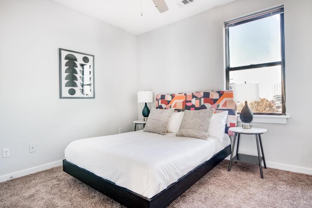 a white bedroom with a bed and a window at CozySuites Music Row Bold 1BR w free parking in Nashville