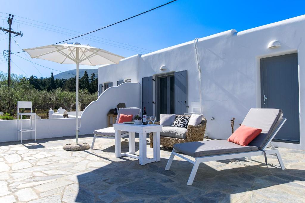 a patio with chairs and a table and an umbrella at Bonzoe #4 in Parikia