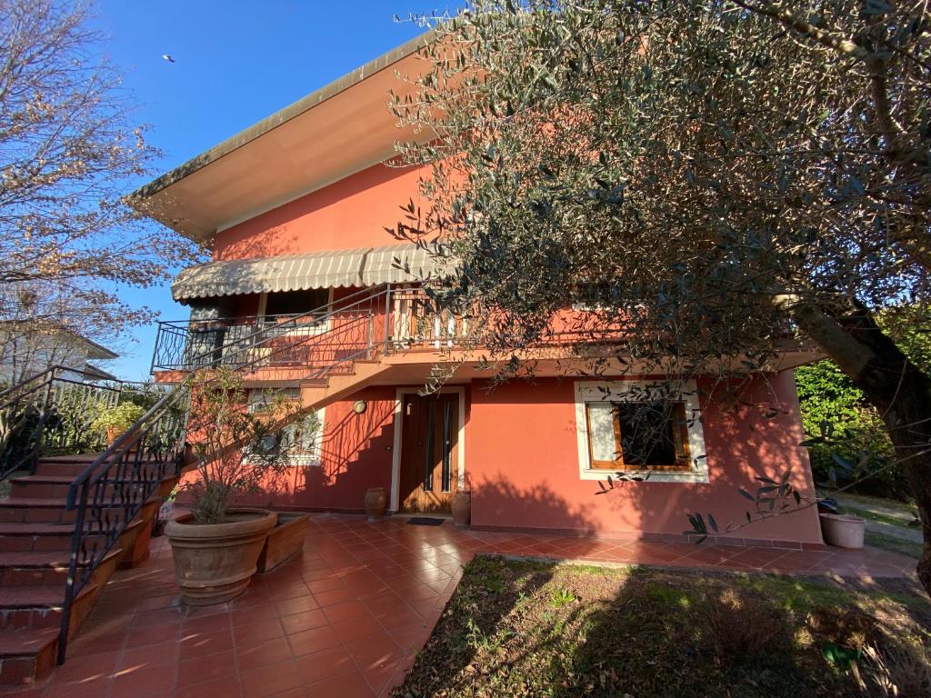 a red house with a staircase in front of it at Spazio Friuli - Soreli Apt residenza nel verde in Sevegliano