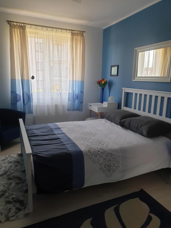 um quarto com uma cama com paredes azuis e uma janela em Nocleg u Kasi TRÓJMIASTO em Kowale