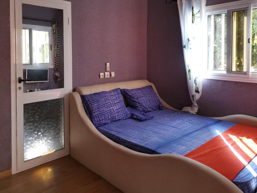 Cama en habitación con bañera junto a una ventana en Agbata Guest House, 