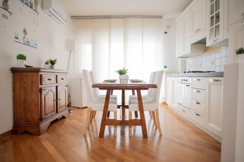 バーリにあるAdriatico Home[Mare-Fiera-Centro]のキッチン(木製テーブル、白いキャビネット付)