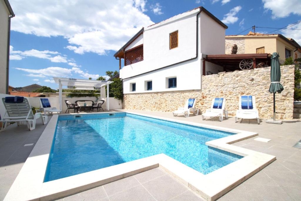 a villa with a swimming pool and a house at Beautiful Dalmatian Stone House with swimming pool in Jezera