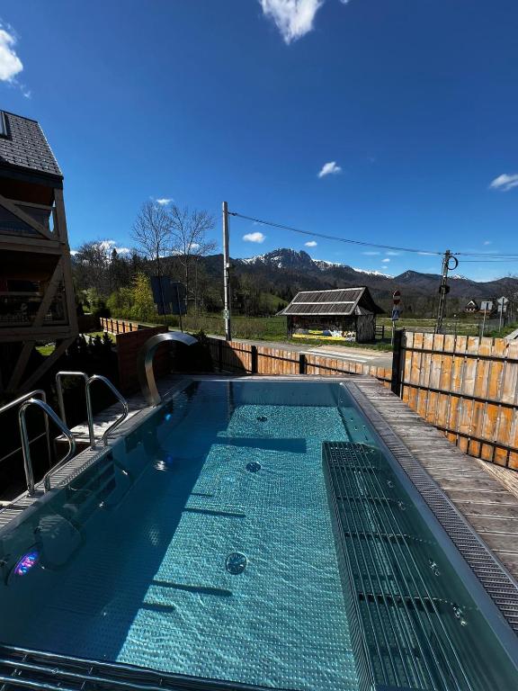 basen z błękitną wodą na podwórku w obiekcie Apartament Morskie Oko Odkryj Zakopane w Zakopanem