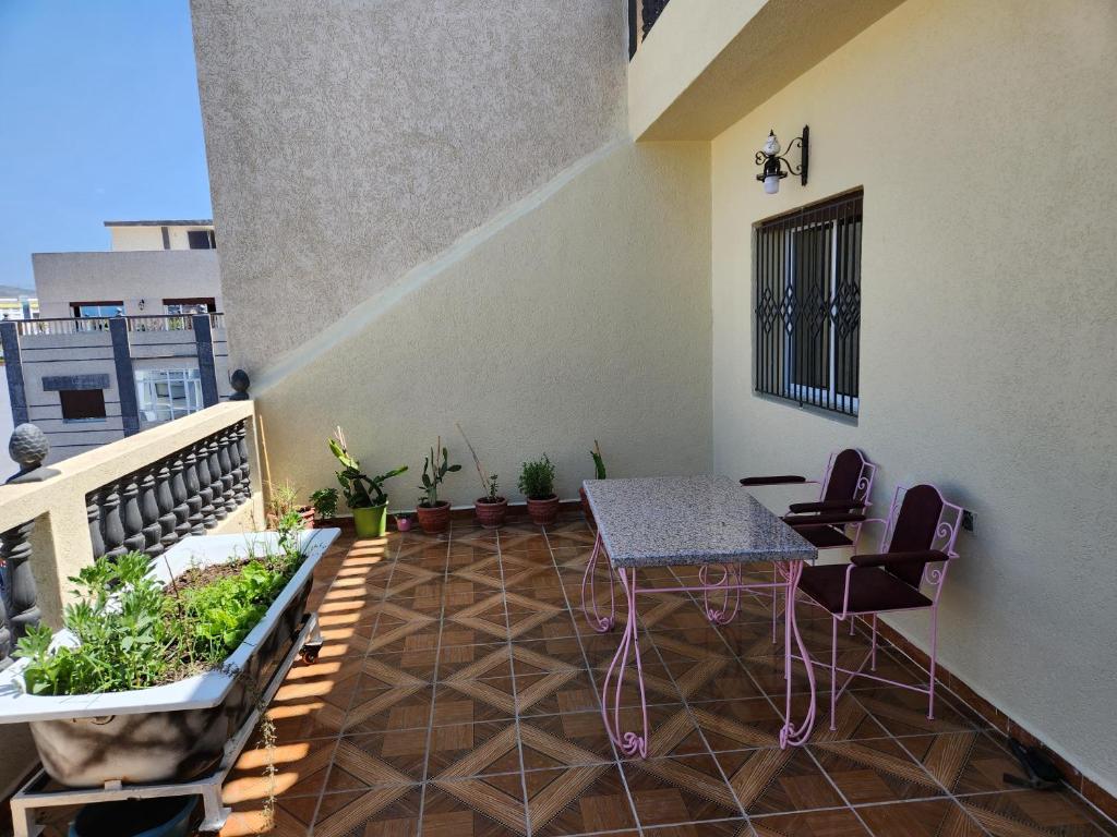 een balkon met een tafel en planten op een gebouw bij Tanger méditerranée in Tanger