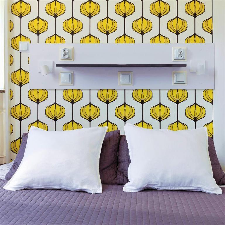 a bedroom with a wall with a yellow flower wallpaper at Tatamka Hostel in Warsaw