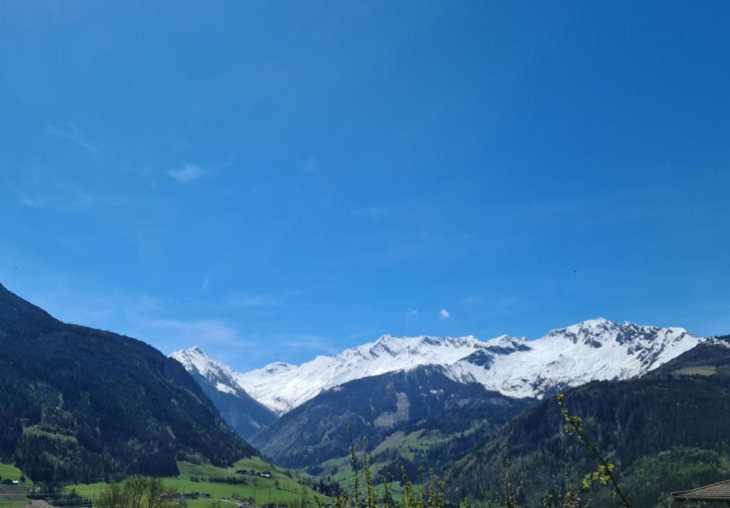 a mountain range with snow capped mountains in the distance at Haus am Sonnberg 24 in Uttendorf