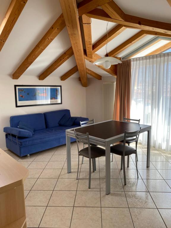 a living room with a table and a blue couch at Casa Gianna in Arco
