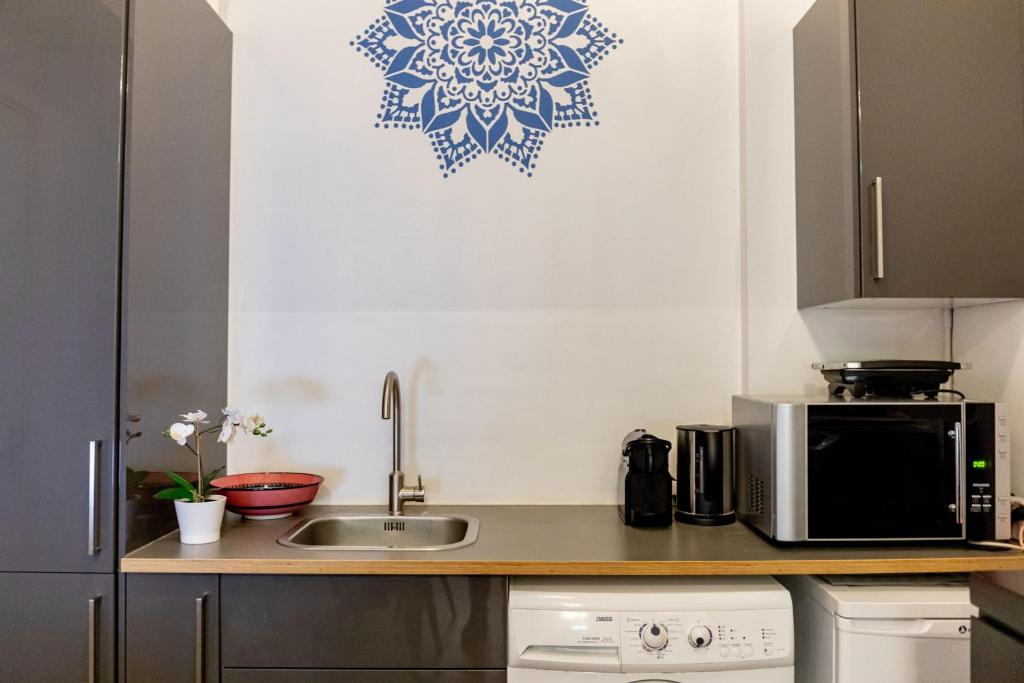 een keuken met een wastafel en een magnetron bij 1001 Nights Boutique Hotel in Haarlem