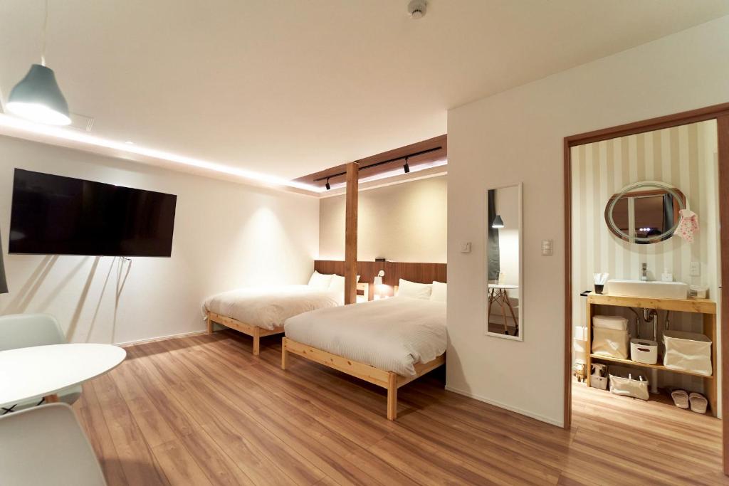 Habitación de hotel con 2 camas y espejo en THE LOBS, RUSUTSU en Kimobetsu