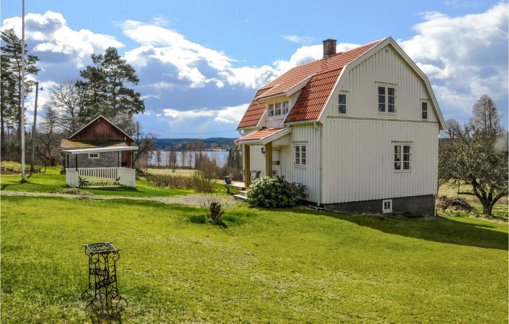 a white house with a red roof in a yard at Amazing Home In rjng With 2 Bedrooms in Årjäng