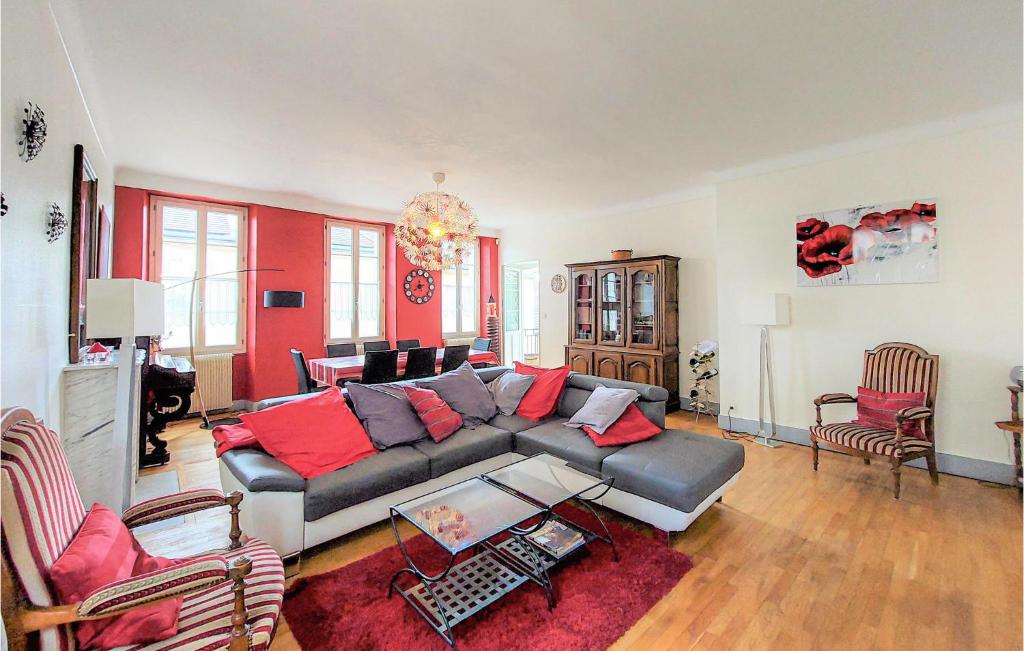 een woonkamer met een grijze bank en rode kussens bij Beautiful Home In Volnay With Wifi in Volnay