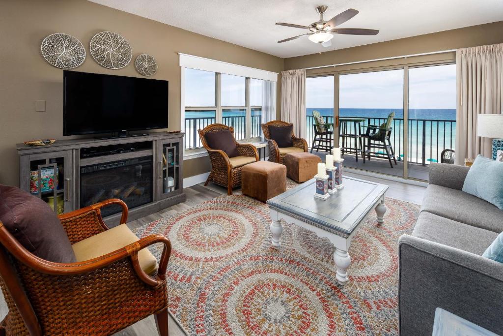 uma sala de estar com uma televisão, um sofá e uma mesa em Emerald Twrs West 4000 by Brooks and Shorey Resorts condo em Fort Walton Beach