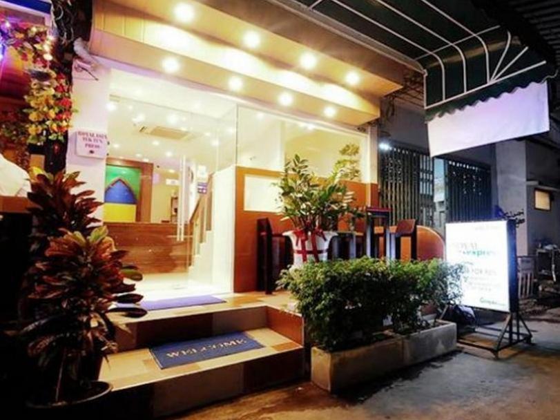un frente de tienda con un banco y plantas delante en Royal Express Inn, en Bangkok