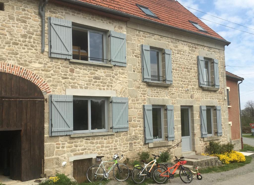 dwa rowery są zaparkowane przed ceglanym budynkiem w obiekcie Roue d'escampette Gîte d'étape et de séjour w mieście Champagnat
