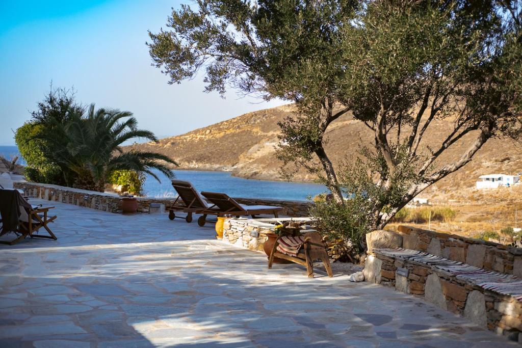 a patio with benches and a view of the water at Villa Mavrianos Sea View in Kithnos