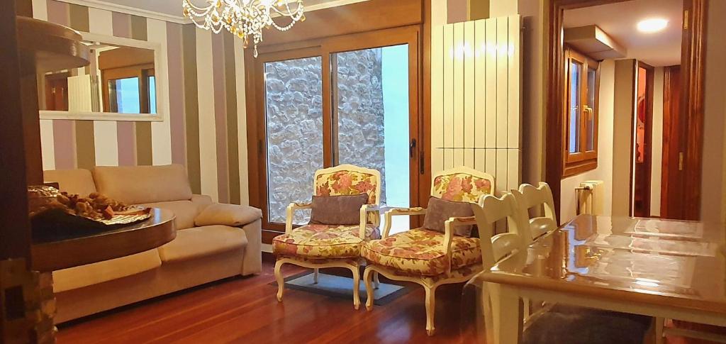ein Wohnzimmer mit einem Sofa, einem Tisch und Stühlen in der Unterkunft La Casa de Lorenzo in Laguardia