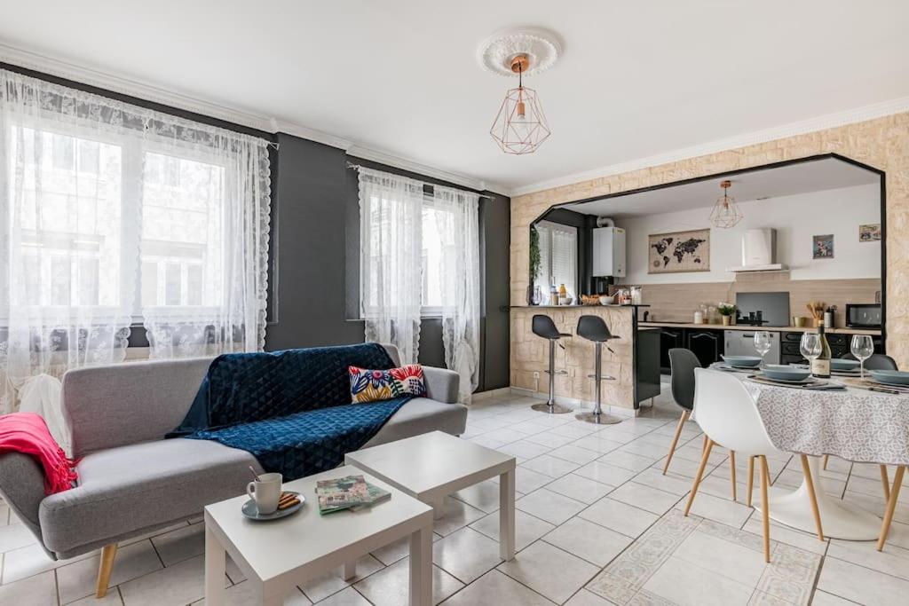 una sala de estar con un sofá y una mesa en Le City Center spacieux et chic, en Saint-Étienne