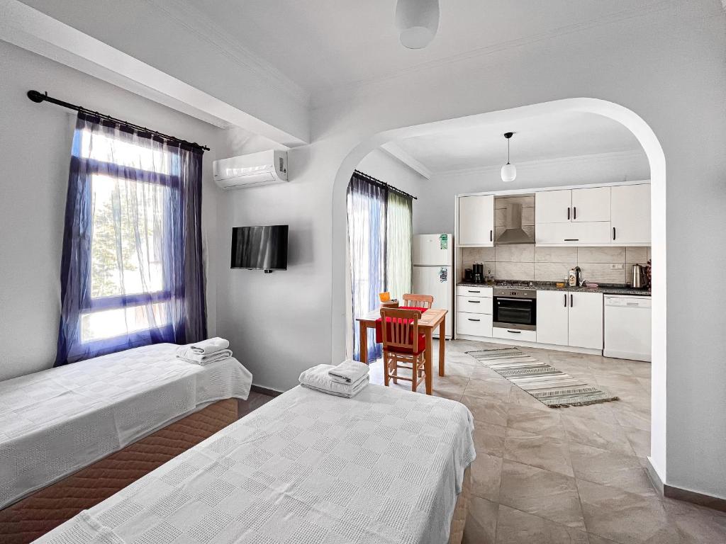 Cette chambre blanche comprend deux lits et une cuisine. dans l'établissement Kaş Merkezde Konforlu Apart-3 The Rush-3, à Kaş