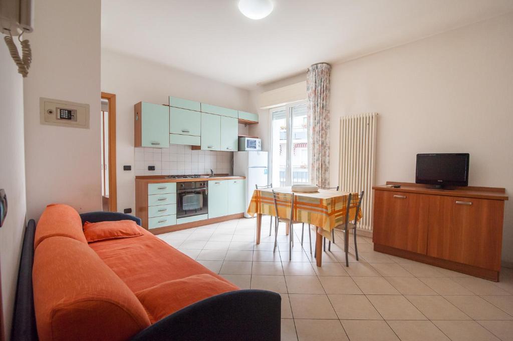 a living room with a couch and a kitchen with a table at APPARTAMENTI SIVIGLIA in Cattolica