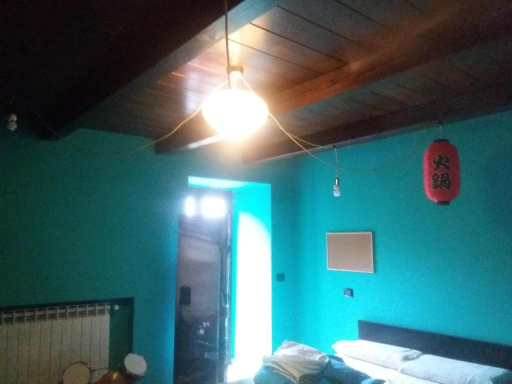 een kamer met een groene muur met een licht en een bank bij Yamabushi B&B in Gravere